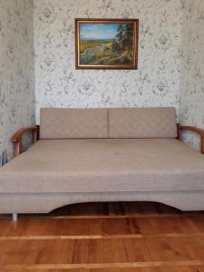Apartment Telbin في كييف: سرير في غرفة مع لوحة على الحائط
