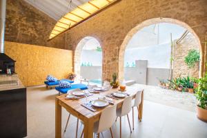 アルクーディアにあるVila Roja, design townhouse in Alcúdiaのレンガの壁のダイニングルーム(テーブル、椅子付)