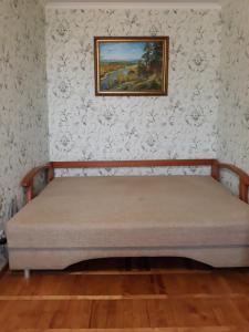 Apartment Telbin في كييف: سرير في غرفة مع لوحة على الحائط