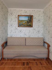 Apartment Telbin في كييف: أريكة في غرفة مع لوحة على الحائط