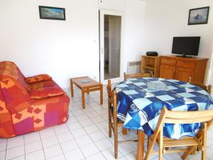a living room with a table and a couch and a television at Appartment Erwan in Arzon