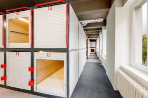 a row of wardrobes in a room with windows at Kapsuła Hostel Warszawa in Warsaw +48 photos