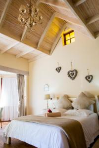 a bedroom with a large bed with a wooden ceiling at Skilpadvlei Wine Farm in Stellenbosch