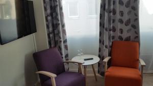 a room with two chairs and a table and a tv at Corner Hotell in Brønnøysund +15 photos