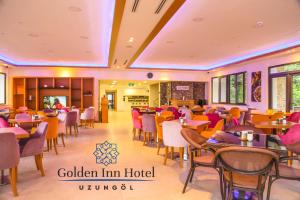 ウズンギョルにあるGolden Inn Hotel Uzungölのレストラン内のダイニングルーム(テーブル、椅子付)