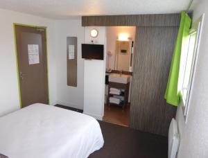 een slaapkamer met een bed en een badkamer met een wastafel bij Hôtel Le Cosy Blois Villebarou in Blois