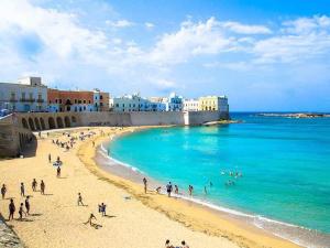 a group of people on a beach near the ocean at Villa Olivia in Tricase