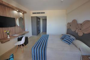 a bedroom with a large bed with blue pillows at Nelia Beach Hotel & Spa in Ayia Napa