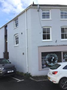 Un bâtiment blanc avec une voiture garée devant. dans l'établissement The Warehouse, à Ulverston