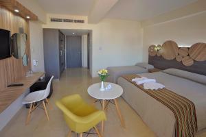 a hotel room with a bed and a table and chairs at Nelia Beach Hotel & Spa in Ayia Napa