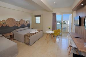 a bedroom with a bed and a table and a television at Nelia Beach Hotel & Spa in Ayia Napa