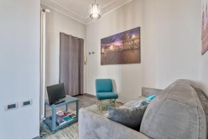 uma sala de estar com um sofá cinzento e uma cadeira azul em Torino Comodo Al Centro em Turim