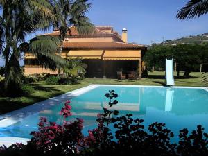 - une piscine en face d'une maison dans l'établissement Lujoso apartamento en Finca Robles 2, à La Orotava