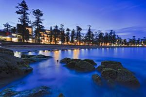una playa por la noche con rocas en el agua en Lotus Stay Manly - Apartment 29G en Sídney