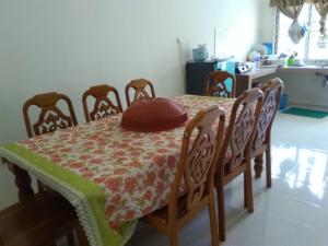 a dining room table and chairs with a table and a hat on it at Homestay Simple in Gambang