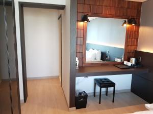 a bathroom with a vanity with a mirror and a stool at Suntree Hotel in Busan