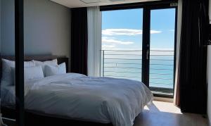 a bedroom with a bed and a large window at Suntree Hotel in Busan