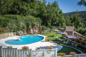 ein Schwimmbad in der Mitte eines Gartens in der Unterkunft Grand Hotel De France in Meyrueis