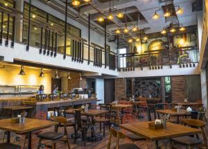 an empty restaurant with wooden tables and chairs at Posto Dormire Hotel in Jakarta
