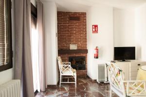 a living room with a brick fireplace and two chairs at Apartamento Centro in Granada