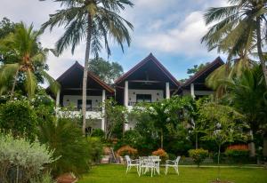 a resort with chairs and palm trees in front of it at Goyambokka Guesthouse in Tangalle
