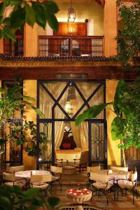 a restaurant with tables and chairs and a balcony at Riad Soundouss in Marrakesh
