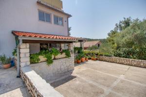 ein Gebäude mit einer Steinmauer mit Pflanzen darauf in der Unterkunft Apartment Simpatico in Čunski + 11 Fotos