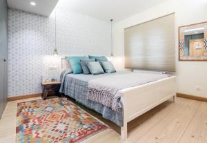 ビルバオにあるBilbao Indautxu I by Aston Rentalsのベッドルーム1室(青い枕とラグ付きのベッド1台付)