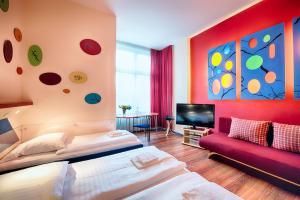 ein Schlafzimmer mit zwei Betten und einem roten Sofa in der Unterkunft Art Hotel Charlottenburger Hof Berlin in Berlin