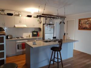 a kitchen with a sink and a counter with a stool at Trading Places Kangaroo Island in Penneshaw
