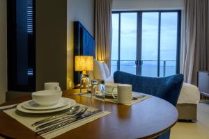 Tanjung Point Residences في جورج تاون: طاولة طعام في غرفة الفندق مع إطلالة