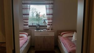 two beds in a small room with a window at Haus Backbord, Wohnung Hauptdeck in Fehmarn