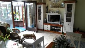 a living room with a tv and a couch at Haus Backbord, Wohnung Hauptdeck in Fehmarn