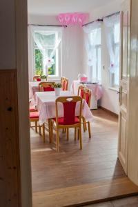 a dining room with a white table and chairs at Penzion Hají in Janov nad Nisou