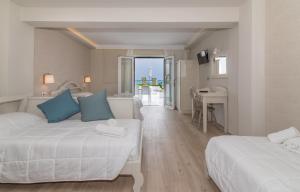 a hotel room with two beds and a balcony at Filoxenia Beach in Tsilivi