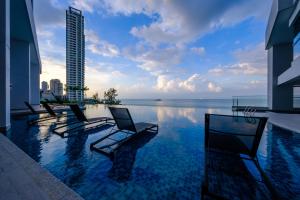 a row of chairs sitting in front of a pool of water at Tanjung Point Residences in George Town