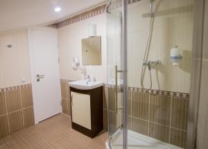 un baño con ducha y lavabo en Hotel Villa Natali, en Chişinău 154 fotos más