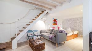 a living room with a couch and a staircase at Can Blau Homes Turismo de Interior in Palma de Mallorca