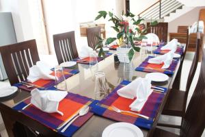 a dining room with a long table with plates and napkins at J's Villa in Nuwara Eliya
