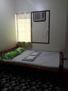 a bedroom with a bed with a mirror and a window at Villa Travellers House in Moalboal