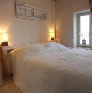 białe łóżko w sypialni z 2 lampami w obiekcie Casa Svalba w Rovinj