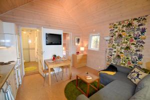 a small living room with a couch and a kitchen at Dragsö Camping & Stugby in Karlskrona