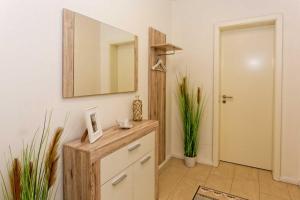 a bathroom with a mirror and a wooden dresser at Kapitaensweg 2 Kajuete 02 in Karlshagen
