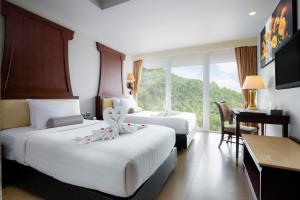 Postel nebo postele na pokoji v ubytování Aiyara Grand Hotel