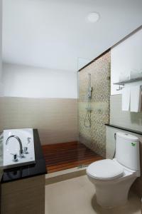 a bathroom with a toilet and a sink and a shower at Aiyara Grand Hotel in Pattaya South