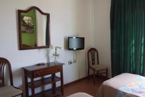 a room with a bed and a mirror and a table at Hotel Ida Inés in Frontera