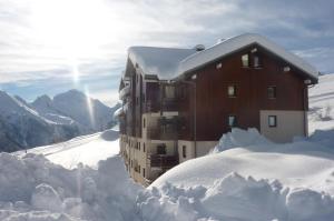 ein schneebedecktes Gebäude mit einem Stapel Schnee in der Unterkunft Ski Sun 3315 in Manigod