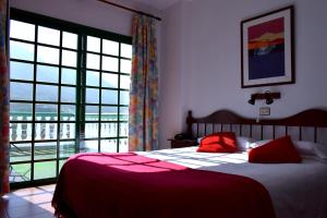 a bedroom with a bed and a large window at Hotel Ida Inés in Frontera