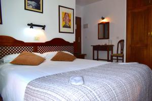 a bedroom with a large white bed and a table at Hotel Ida Inés in Frontera