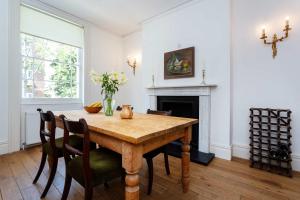 a dining room with a table with chairs and a fireplace at Veeve - Sloane Square Hideaway in London